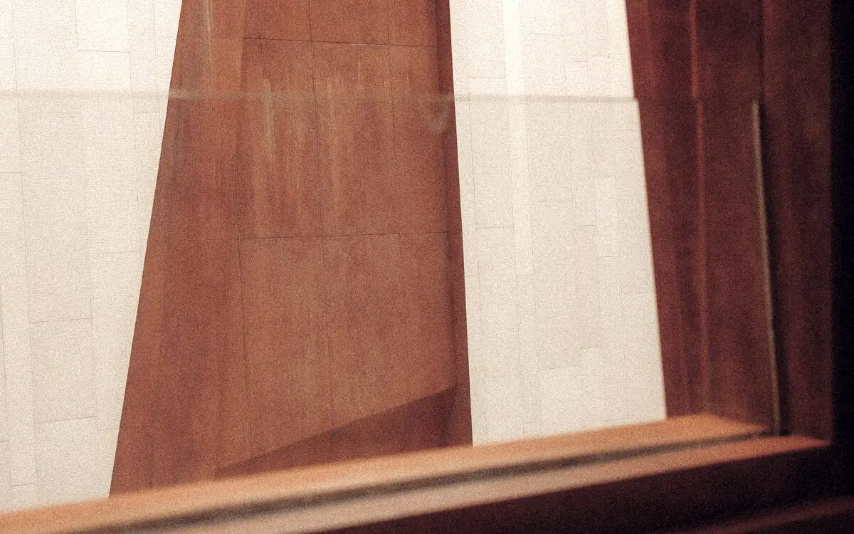 Architectural detail of a timber panel against pale stone